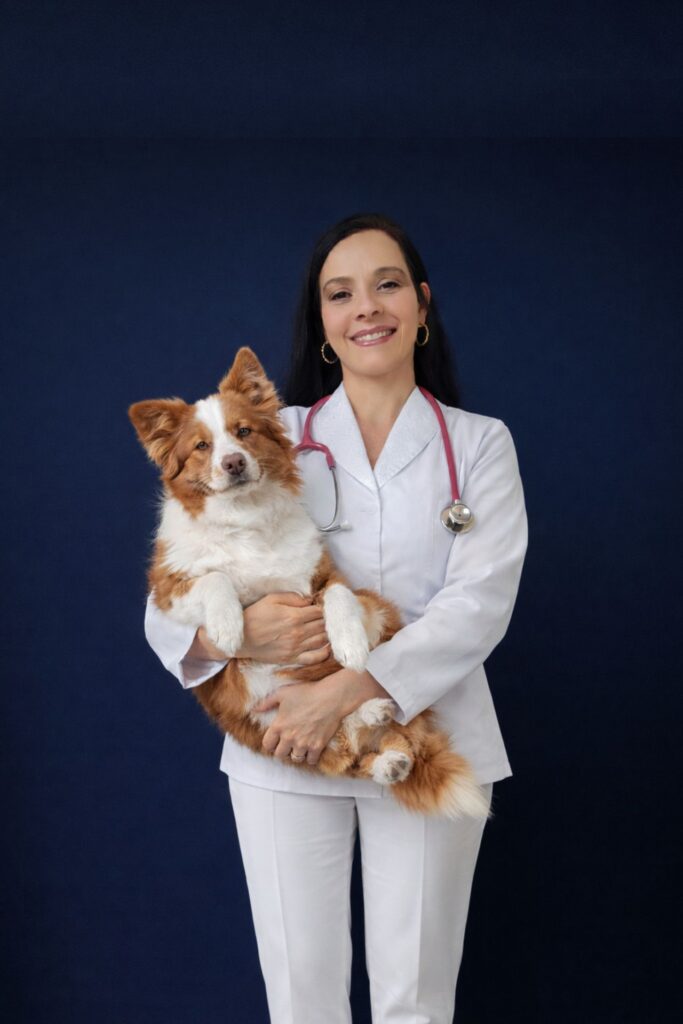 Dra Bárbara mariano vestida de branco segurando um cachorro branco e marrom no colo